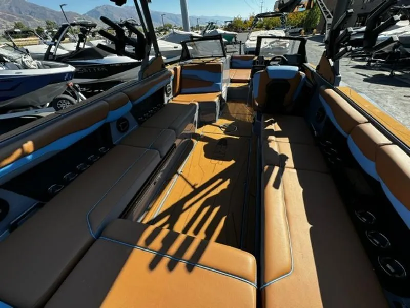 Slide: The Image of 2024 Axis T250 boat interior with tan and blue seating, docked outdoors. - 10