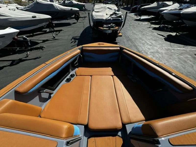 Slide: The Image of 2024 Axis T250 boat interior with tan seating, docked among other boats. - 12