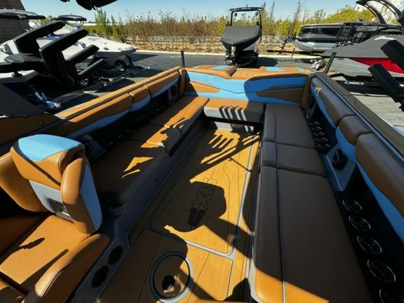 Slide: The Image of 2024 Axis T250 boat interior with brown and blue seating, docked outdoors. - 13