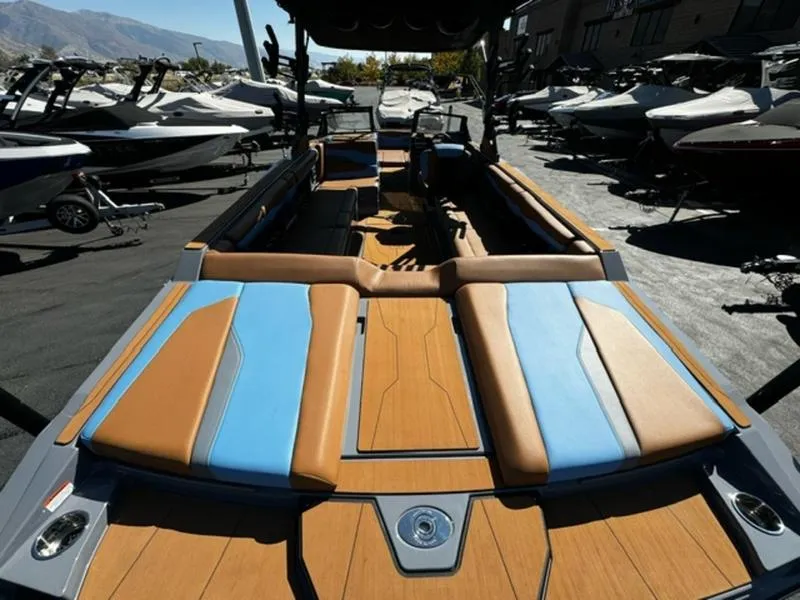 Slide: The Image of 2024 Axis T250 boat interior with brown and blue seating, docked among other boats. - 3