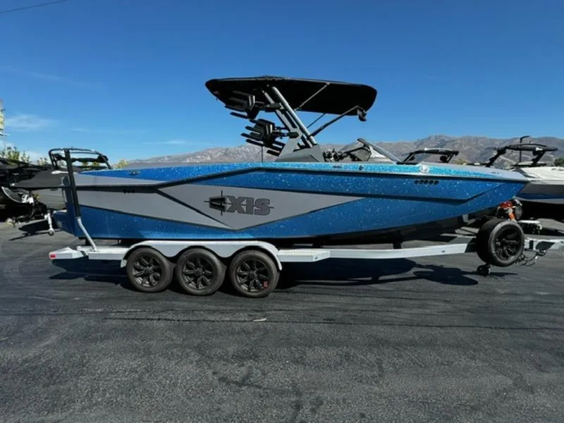 Slide: The Image of 2024 Axis T250 boat on trailer, blue and gray design, parked outdoors. - 5