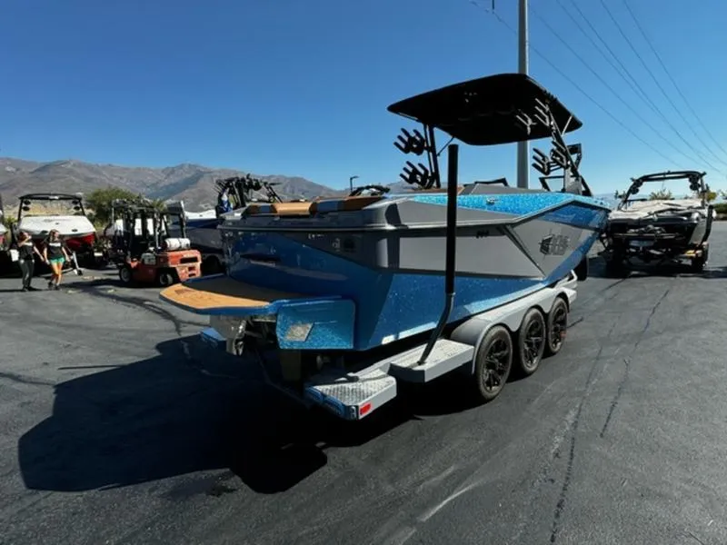 Slide: The Image of 2024 Axis T250 boat on trailer, blue exterior, parked outdoors under clear sky. - 6