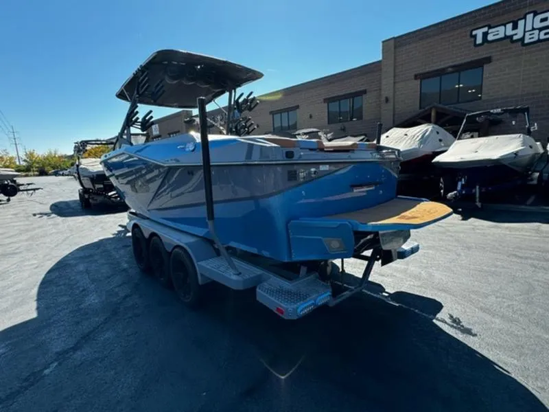 Slide: The Image of 2024 Axis T250 boat on trailer, parked outside dealership under clear blue sky. - 7