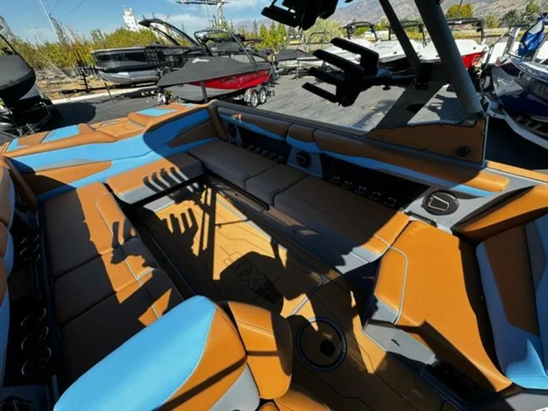 Slide: The Image of 2024 Axis T250 boat interior with brown and blue seating, docked among other boats. - 8