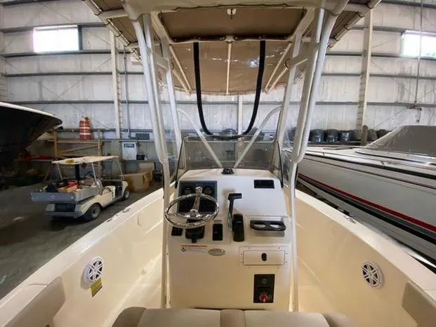 Slide: The Image of 2024 Scout 195 Sportfish boat interior with steering console in a storage facility. - 6
