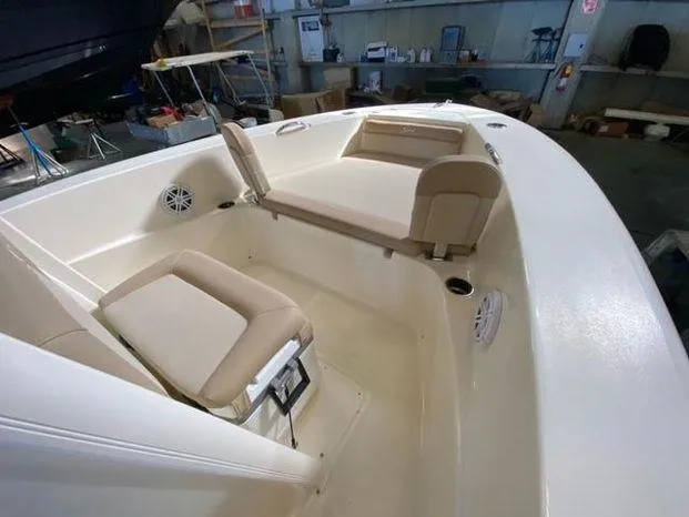 Slide: The Image of 2024 Scout 195 Sportfish boat interior with beige seating in a workshop. - 8