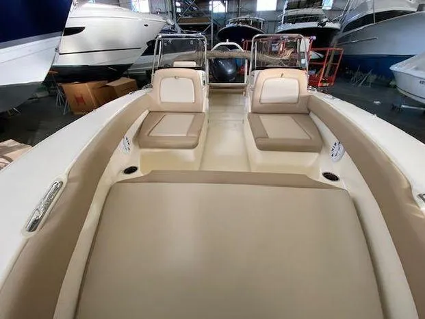 Slide: The Image of 2024 Scout 195 Sport Dorado boat interior with beige seating in a showroom. - 10