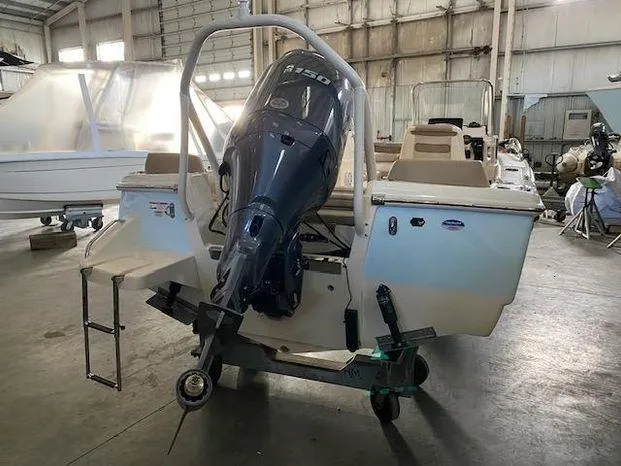 Slide: The Image of 2024 Scout 195 Sport Dorado boat in a warehouse, rear view with outboard motor. - 4