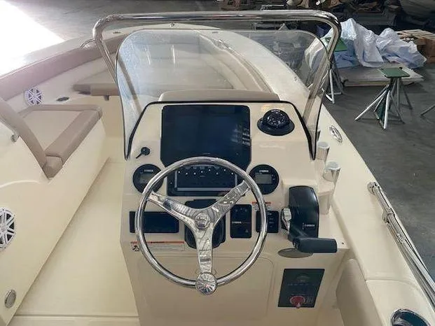 Slide: The Image of 2024 Scout 195 Sport Dorado boat dashboard with steering wheel and control panel. - 6