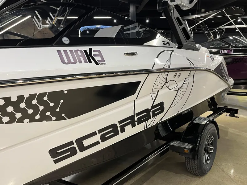 Slide: The Image of 2024 Scarab 215 Wake ID boat in showroom, side view with graphics. - 8