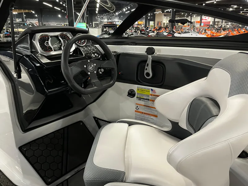 Slide: The Image of Interior cockpit of 2024 Scarab 215 Wake ID boat with steering wheel and captain's chair. - 9