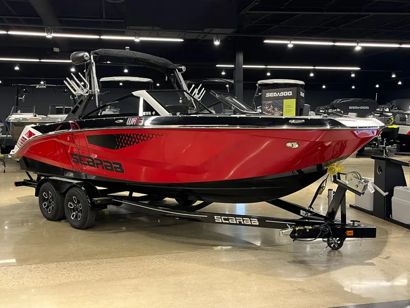 Slide: The Image of 2024 Scarab 235 Wake ID boat in showroom, red and black design. - 3