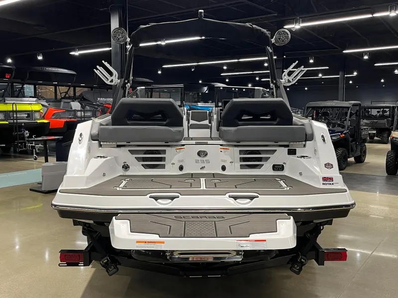 Slide: The Image of 2024 Scarab 235 Wake ID boat, rear view in showroom with dual seats and wakeboard tower. - 5