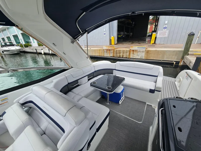 Slide: The Image of 2018 Formula 350 Sun Sport boat interior with white seating and a small table. - 14