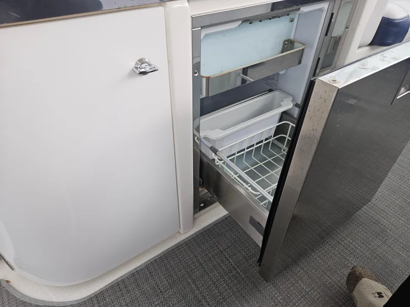 Slide: The Image of Open refrigerator drawer on 2018 Formula 350 Sun Sport boat, showcasing interior storage. - 35