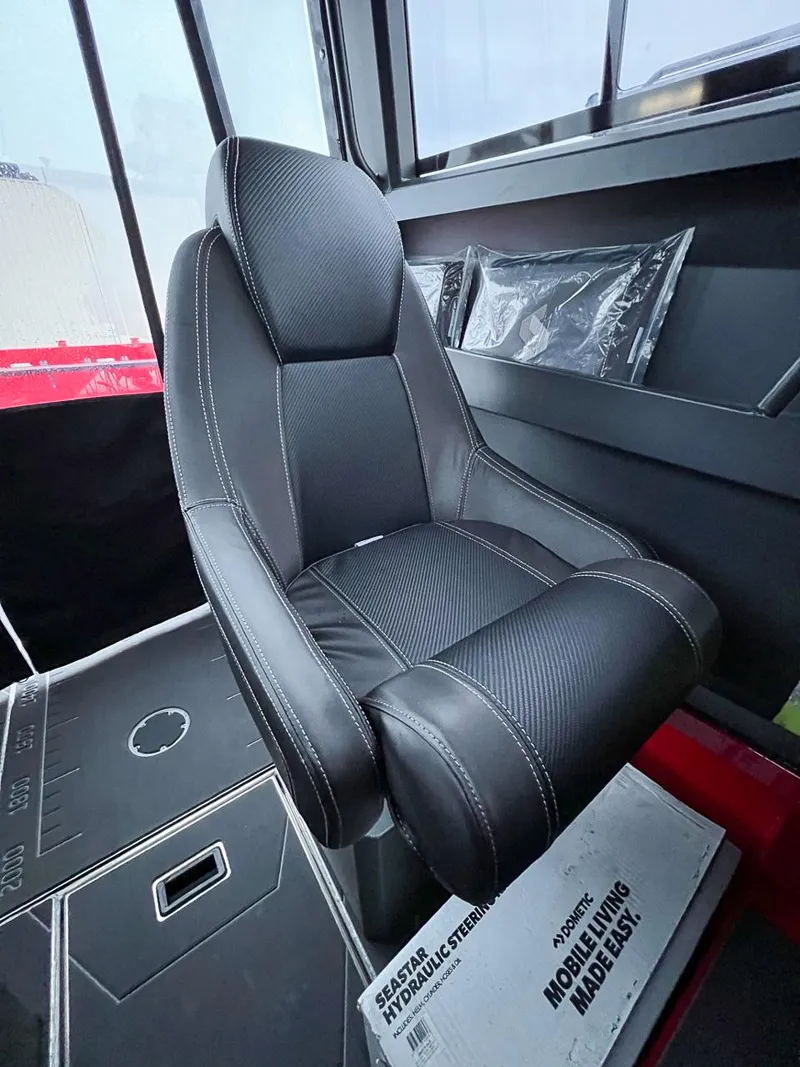 Slide: The Image of 2024 Stabicraft 2250 Alpha Ultra Centrecab interior with black captain's chair and hydraulic steering system. - 14