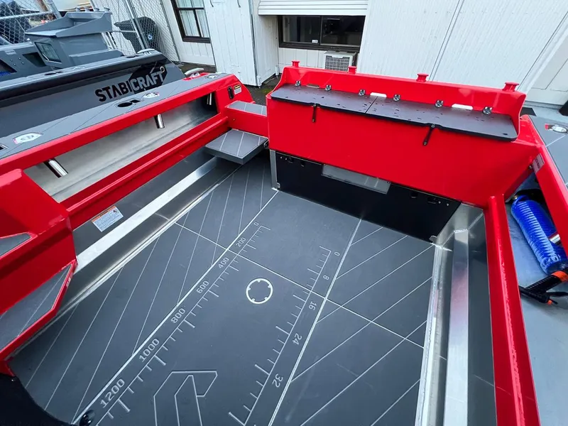Slide: The Image of 2024 Stabicraft 2250 Alpha Ultra Centrecab boat interior with red accents and measurement markings. - 21