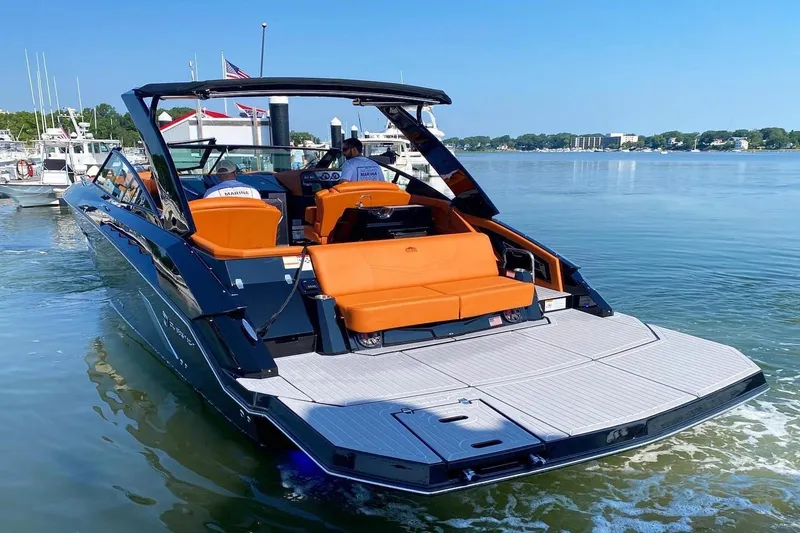 Slide: The Image of 2021 Cruisers Yachts 338 CX in marina, featuring orange seating and sleek design. - 12