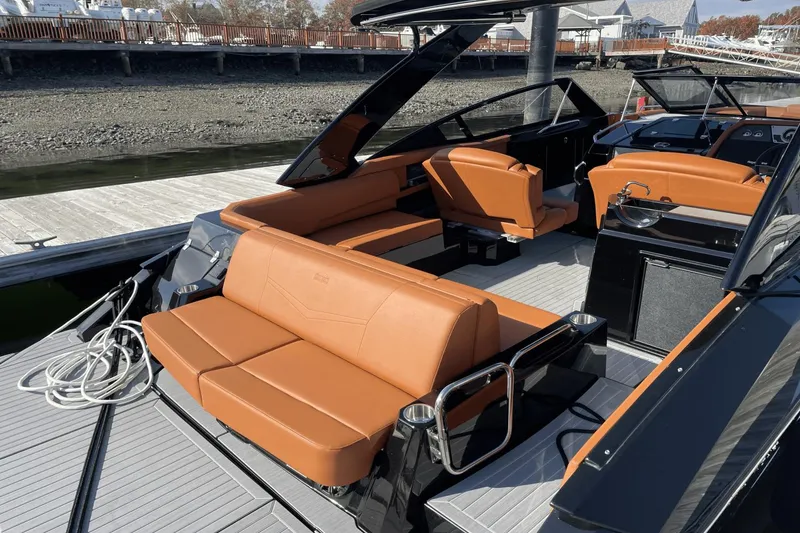 Slide: The Image of 2021 Cruisers Yachts 338 CX with tan leather seating, docked at a marina. - 13