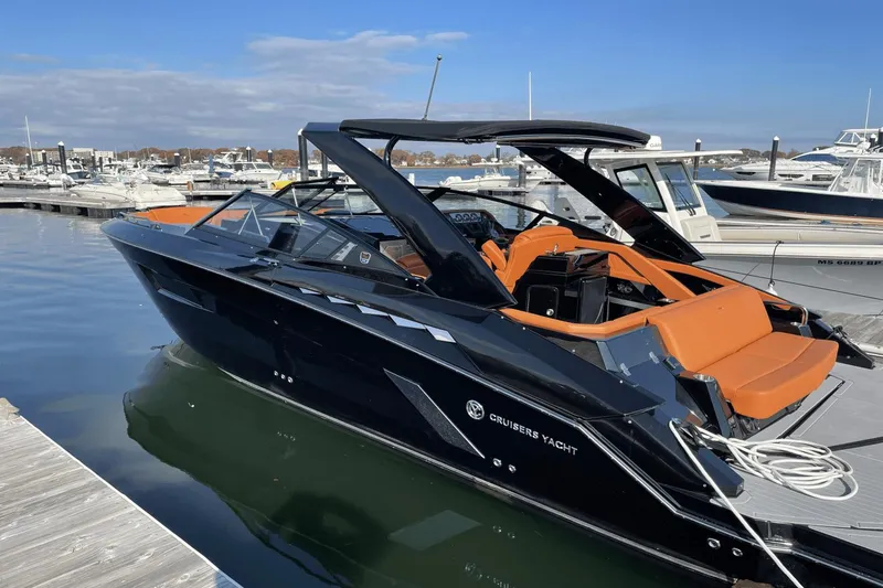Slide: The Image of 2021 Cruisers Yachts 338 CX docked, featuring sleek black design and orange interior. - 14