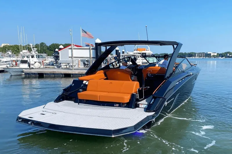Slide: The Image of 2021 Cruisers Yachts 338 CX in marina, featuring orange seating and sleek design. - 3