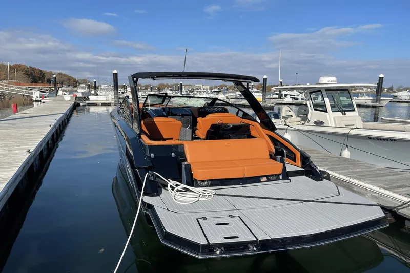 Slide: The Image of 2021 Cruisers Yachts 338 CX docked at a marina with orange seating. - 7
