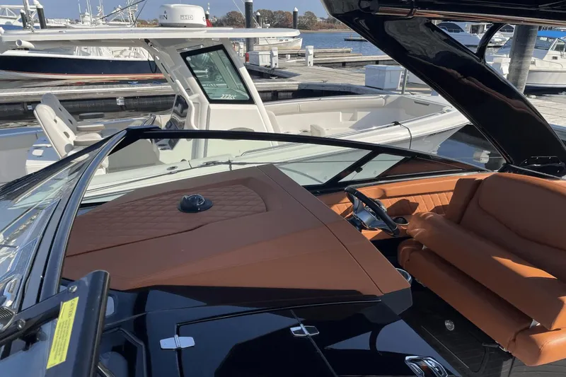 Slide: The Image of 2021 Cruisers Yachts 338 CX with luxurious brown leather seating at the marina. - 9