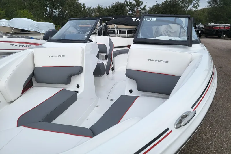 Slide: The Image of 2024 Tahoe 210 S boat with white and gray interior, docked outdoors. - 4