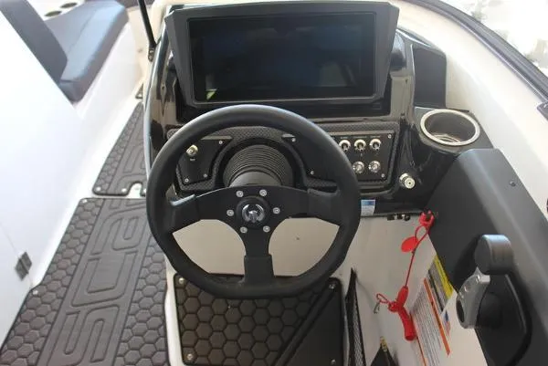 Slide: The Image of 2023 Scarab 255 ID boat dashboard with steering wheel and touchscreen display. - 6