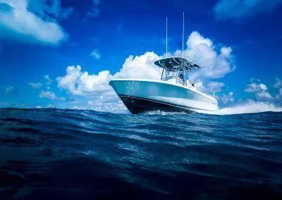 Slide: The Image of 2024 Contender 24 Sportfish boat cruising on open ocean under blue sky. - 12
