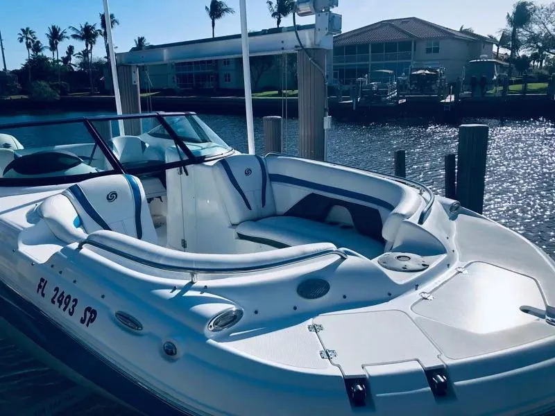 Slide: The Image of 2019 Godfrey Hurricane SD2200 boat docked by waterfront homes. - 1