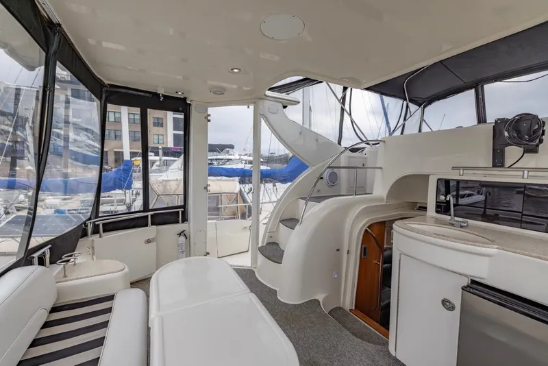 Slide: The Image of 2004 Meridian 459 Motoryacht interior with seating, kitchenette, and marina view. - 14