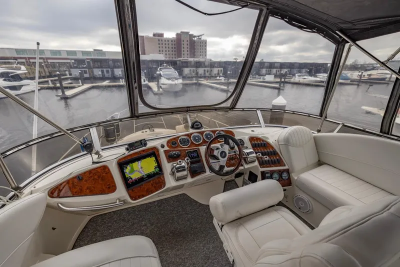 Slide: The Image of 2004 Meridian 459 Motoryacht helm with marina view, featuring luxurious seating and advanced navigation controls. - 18