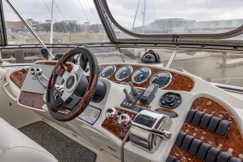 Slide: The Image of 2004 Meridian 459 Motoryacht helm with wood accents and modern controls. - 19