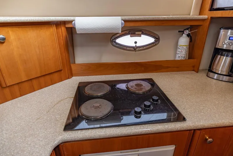 Slide: The Image of 2004 Meridian 459 Motoryacht kitchen with stovetop, paper towel holder, and coffee maker. - 31