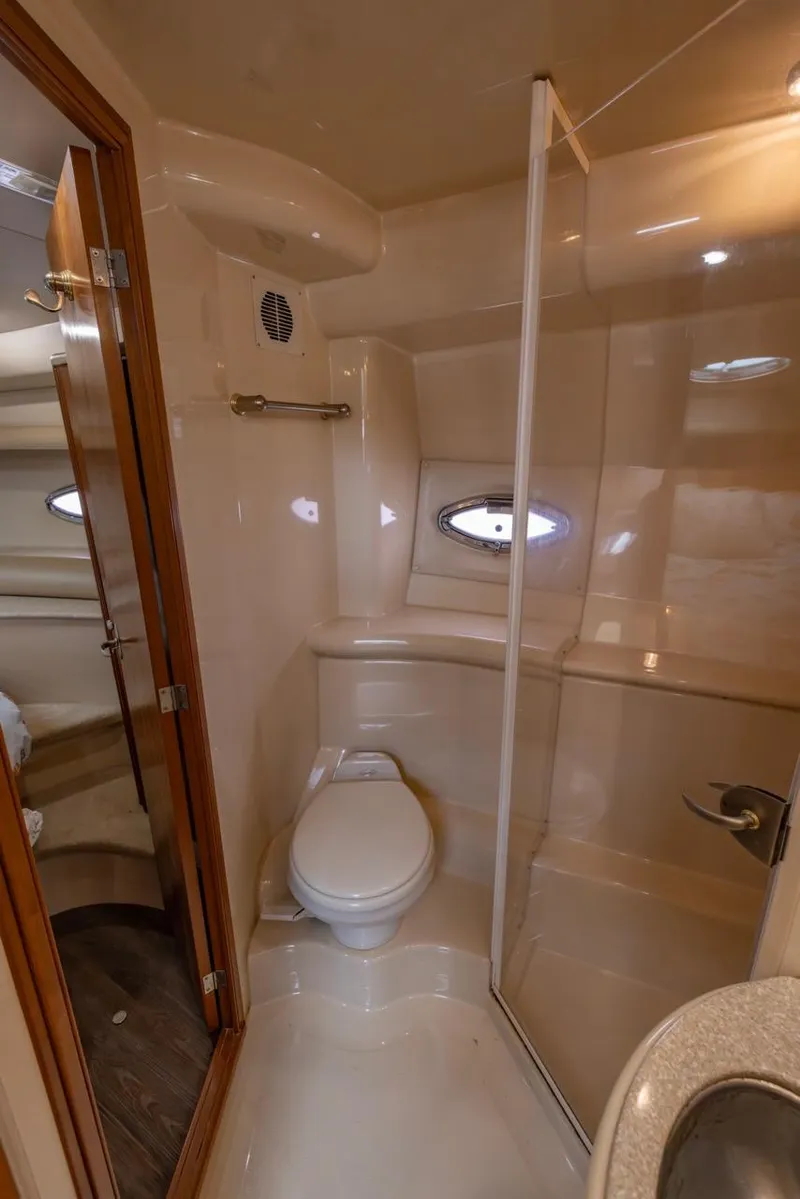 Slide: The Image of 2004 Meridian 459 Motoryacht bathroom with shower, toilet, and porthole window. - 34