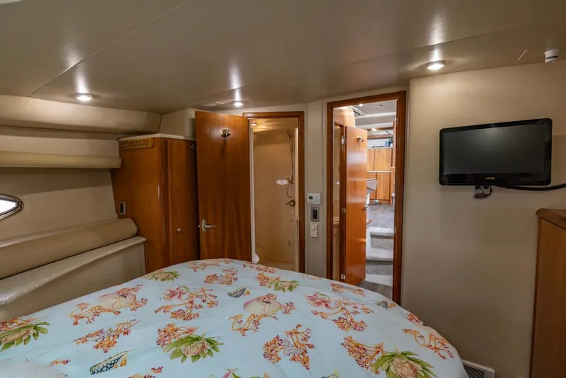 Slide: The Image of 2004 Meridian 459 Motoryacht bedroom with floral bedding, TV, and wooden cabinetry. - 36