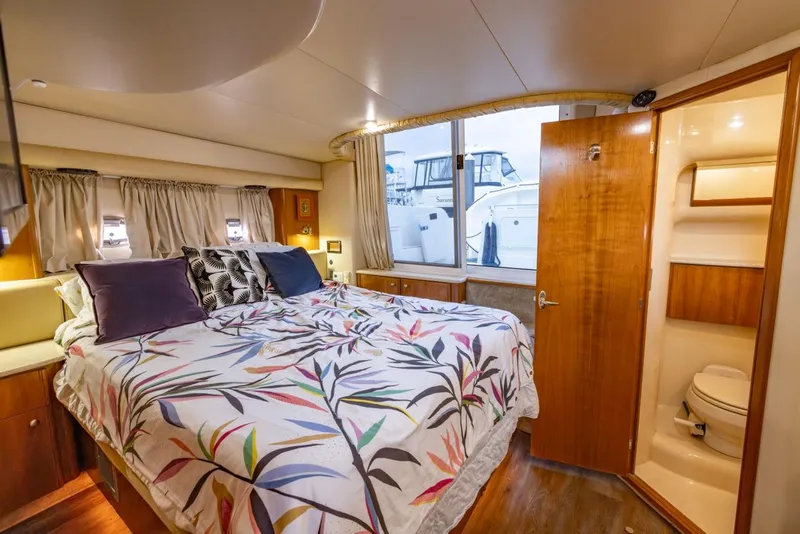 Slide: The Image of Luxurious 2004 Meridian 459 Motoryacht bedroom with ensuite bathroom and vibrant bedding. - 37