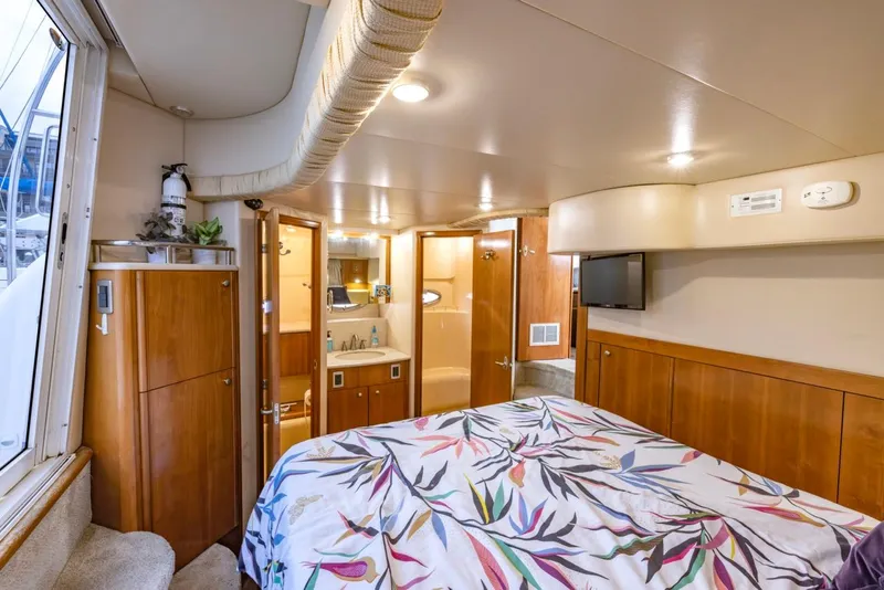 Slide: The Image of Luxurious 2004 Meridian 459 Motoryacht bedroom with floral bedding and wooden cabinetry. - 38