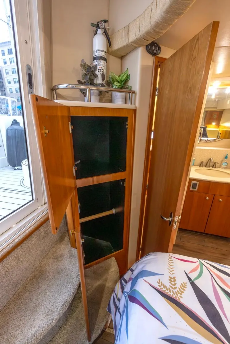 Slide: The Image of 2004 Meridian 459 Motoryacht interior with open wooden cabinet and fire extinguisher. - 39