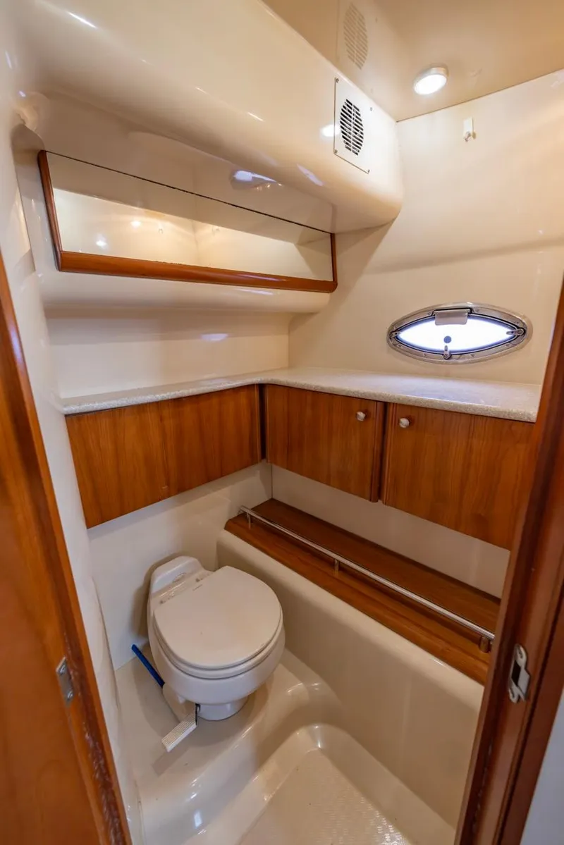 Slide: The Image of 2004 Meridian 459 Motoryacht bathroom with wood accents and porthole window. - 41