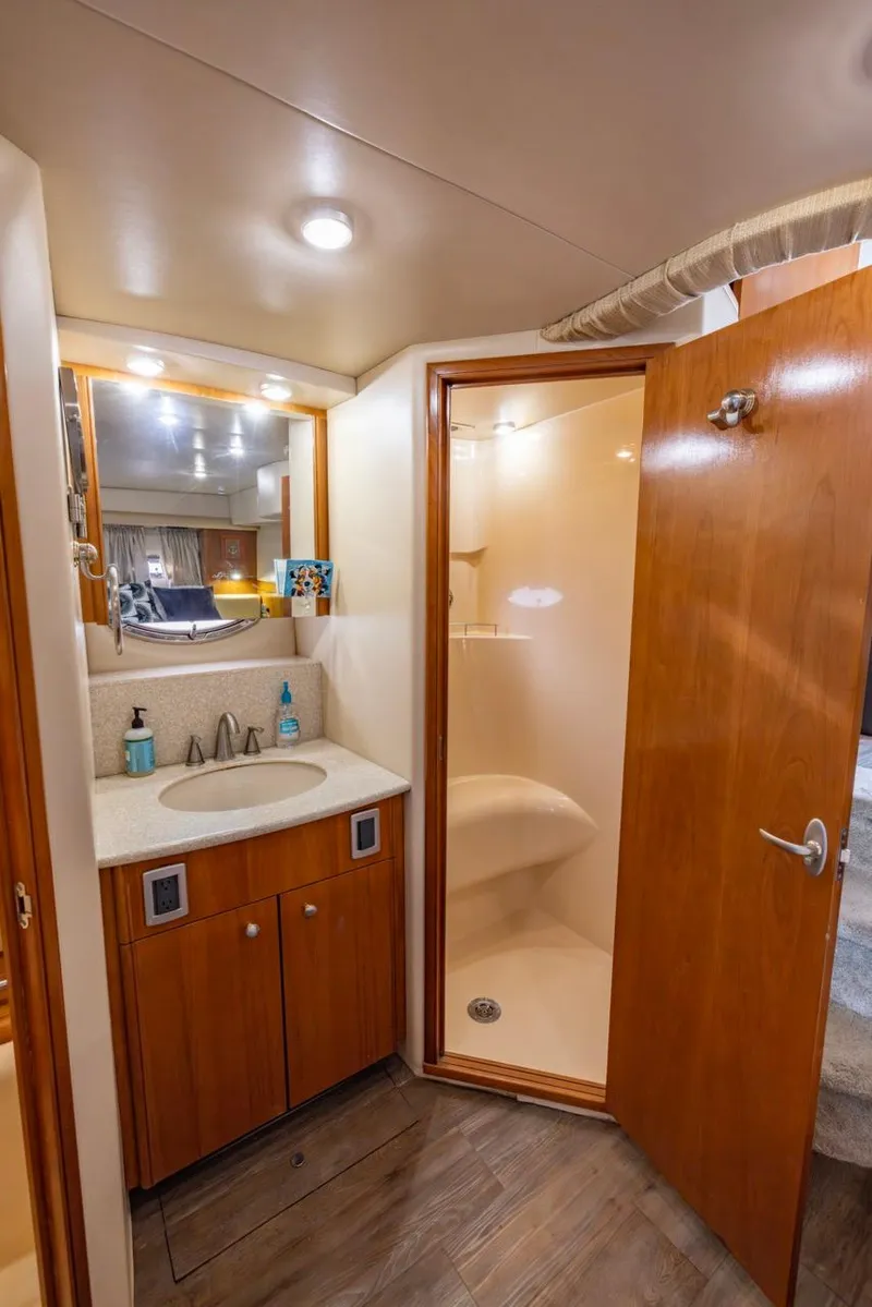 Slide: The Image of 2004 Meridian 459 Motoryacht bathroom with shower, sink, and wooden cabinetry. - 42