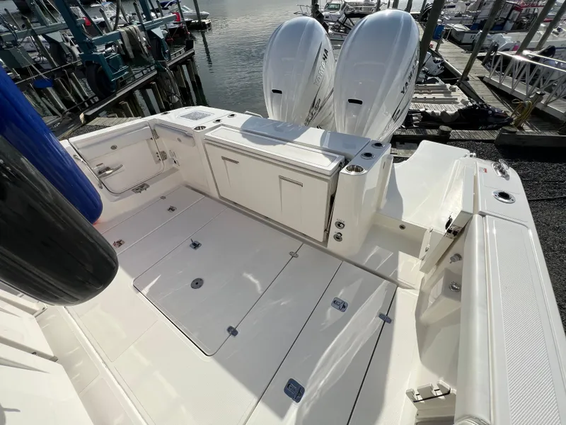 Slide: The Image of 2022 Pursuit S 358 boat deck with twin outboard engines at marina. - 11