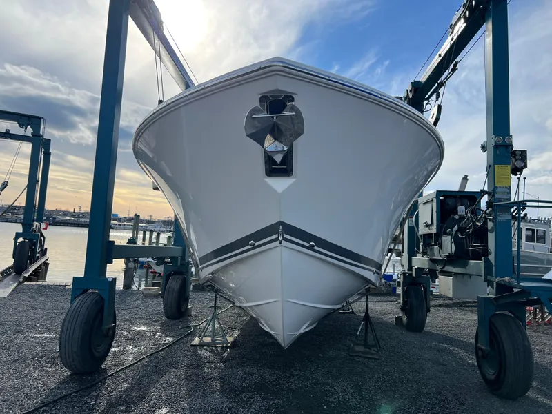 Slide: The Image of 2022 Pursuit S 358 boat on a lift at a marina, under a cloudy sky. - 2