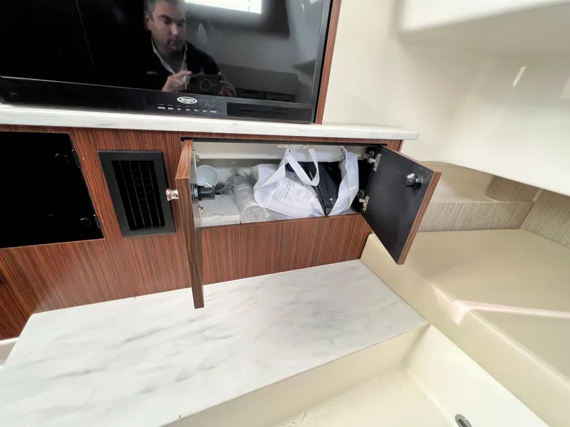 Slide: The Image of 2022 Pursuit S 358 interior with open cabinet and TV. - 27