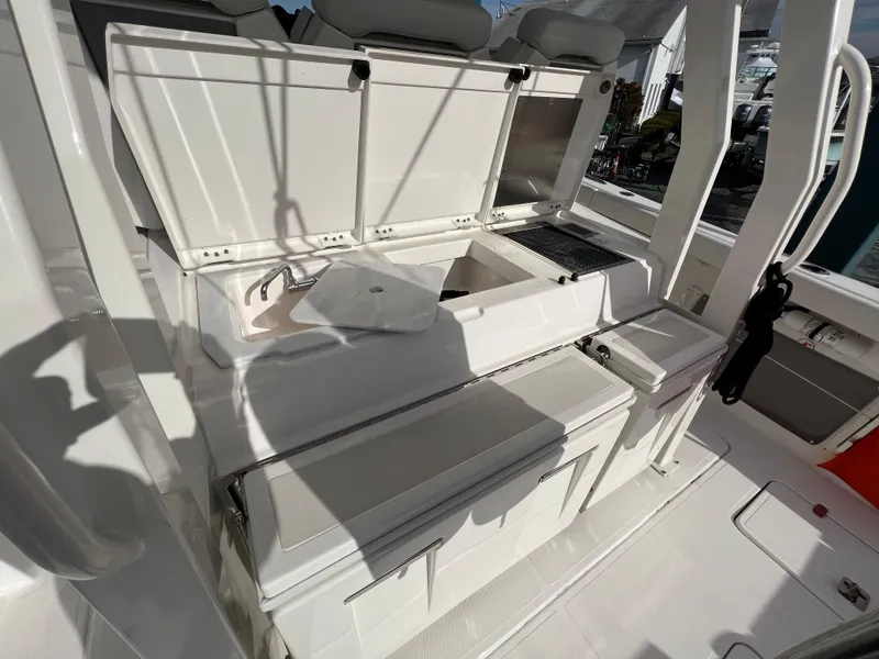 Slide: The Image of 2022 Pursuit S 358 boat interior with open storage compartments and seating. - 35