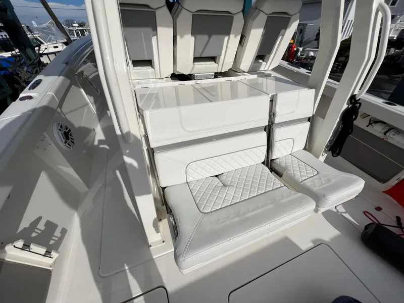 Slide: The Image of 2022 Pursuit S 358 boat interior with white cushioned seating and sleek design. - 36