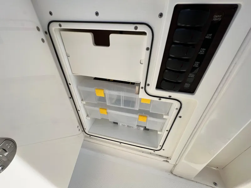 Slide: The Image of 2022 Pursuit S 358 boat storage compartment with organized tackle boxes. - 38