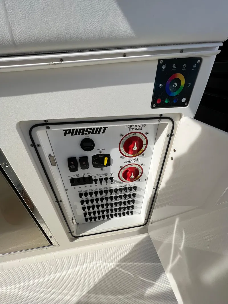 Slide: The Image of Control panel of 2022 Pursuit S 358 boat with color-coded switches and dials. - 42
