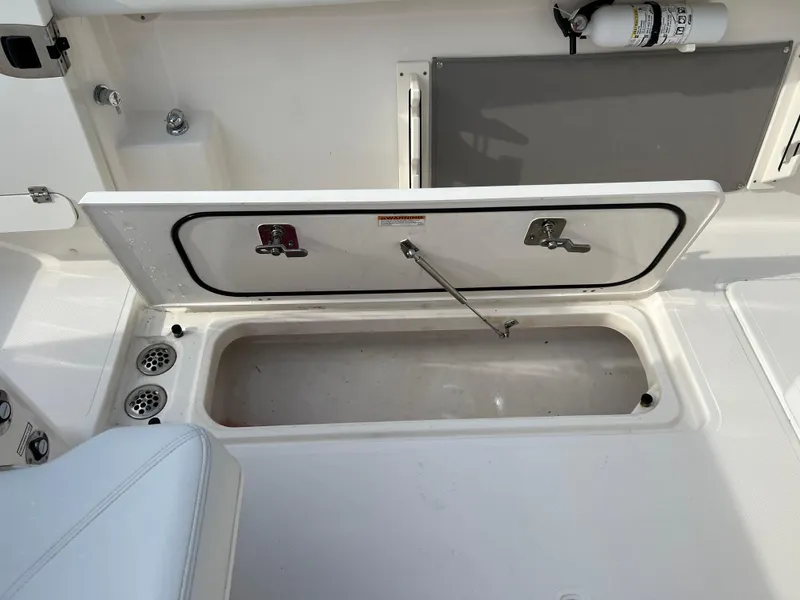 Slide: The Image of 2022 Pursuit S 358 boat storage compartment with open hatch and fire extinguisher. - 47